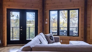 Una habitación acogedora con un ventanal grande, un sofá y una puerta que da a una terraza exterior.