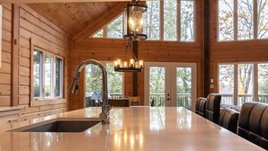 Un'ampia cucina con un'isola grande, un rubinetto moderno e un lampadario a sospensione.