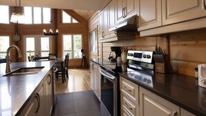 A modern kitchen with wooden cabinets, a stainless steel sink, and a large island.