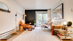 Una sala de estar moderna con chimenea, un sofá, un sillón y una estantería.