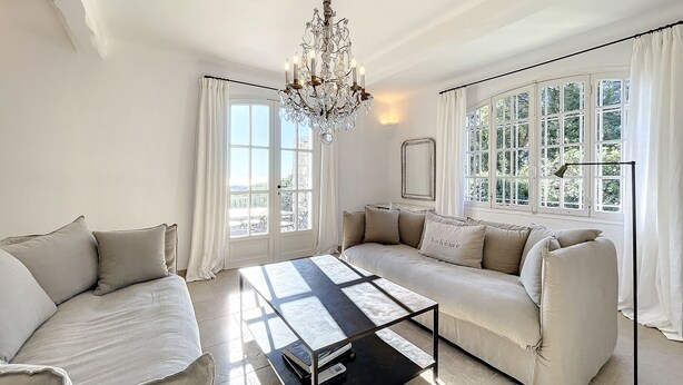 A spacious living room with a sofa, a coffee table, and a chandelier. - Charming villa with garden and heated pool, perfect families (Saint Paul de Vence)