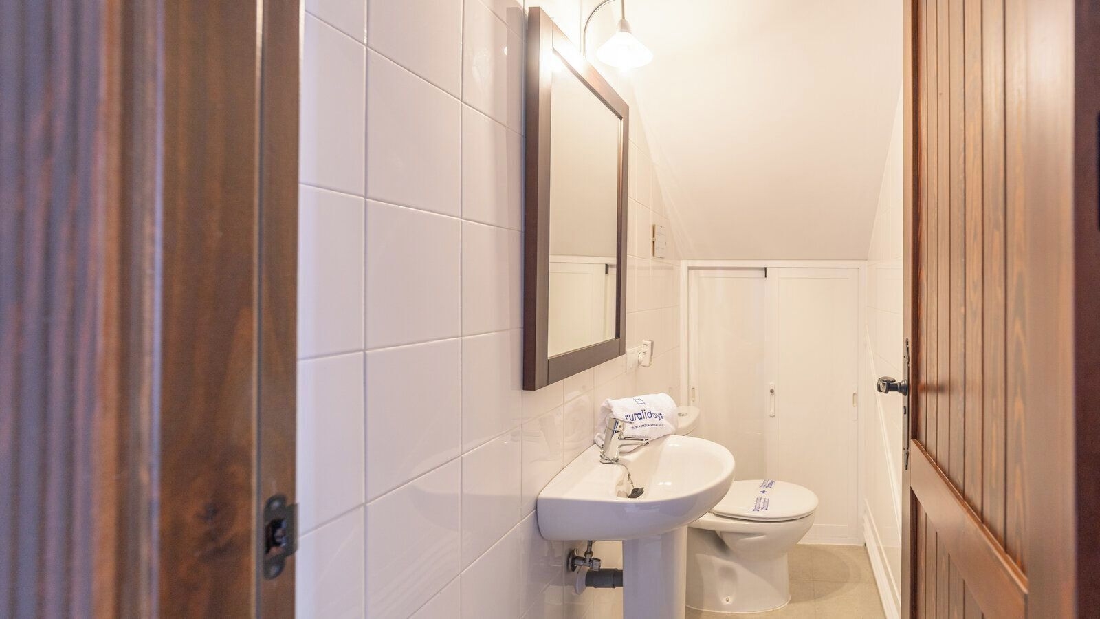 A bathroom with a sink, mirror, and toilet.