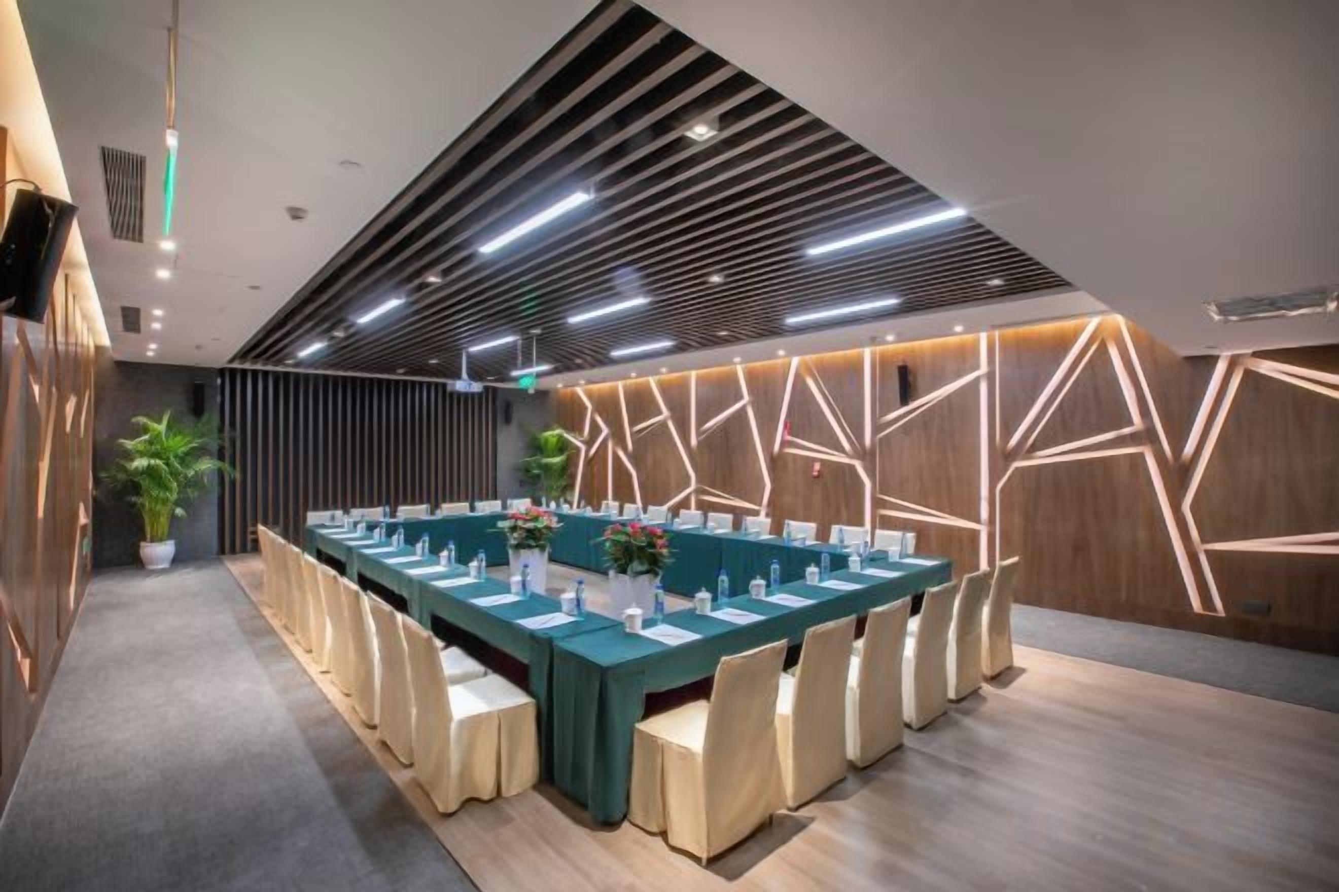 A conference room with a long table, chairs, and a modern ceiling design.