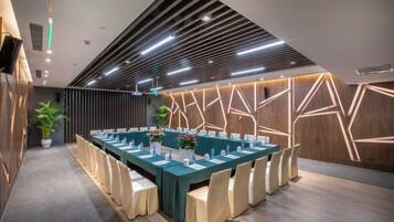 A conference room with a long table, chairs, and a modern ceiling design.