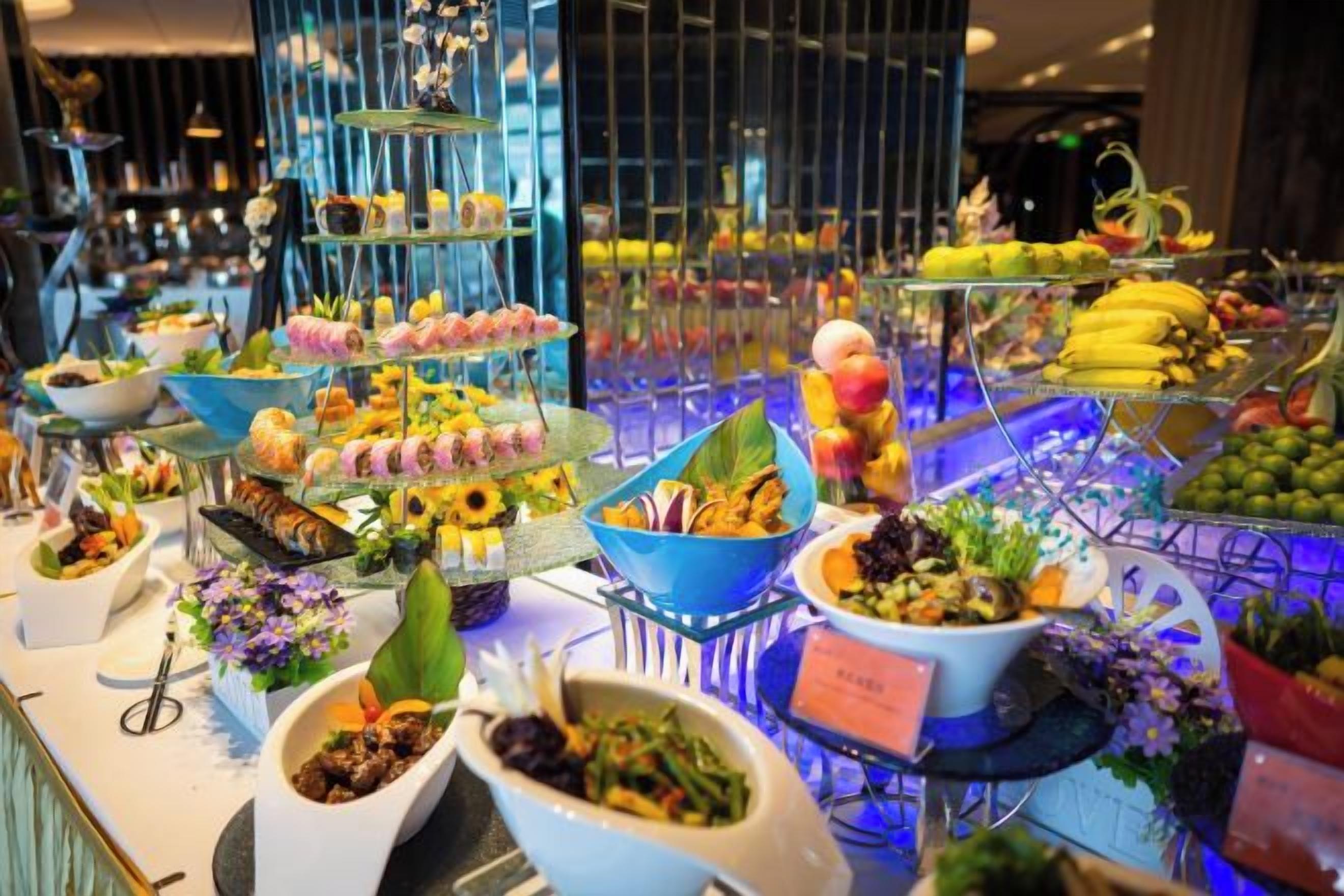 A buffet with various food items and a tiered dessert display.