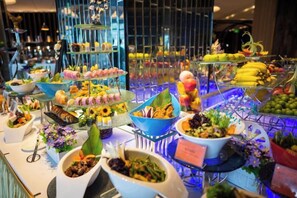 Un buffet proposant une variété de plats et une présentation de desserts en étages.