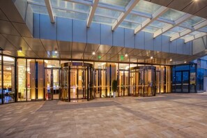 A hotel entrance with revolving doors, a glass ceiling, and a tiled floor. - Like Hotel (Guiyang)