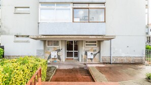 Un edificio moderno con techo plano, ventanas amplias y una entrada central.