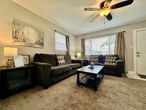 Ein Wohnzimmer mit einer Couch, einem Couchtisch und einem Deckenventilator.