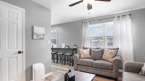 A living room with a grey sofa, a wooden coffee table, and a ceiling fan. - 17 S First - Unit 6 · 17 s first street unit 6 (Trenton)