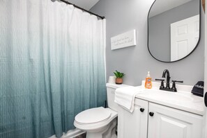 A bathroom with a toilet, sink, and a shower curtain.
