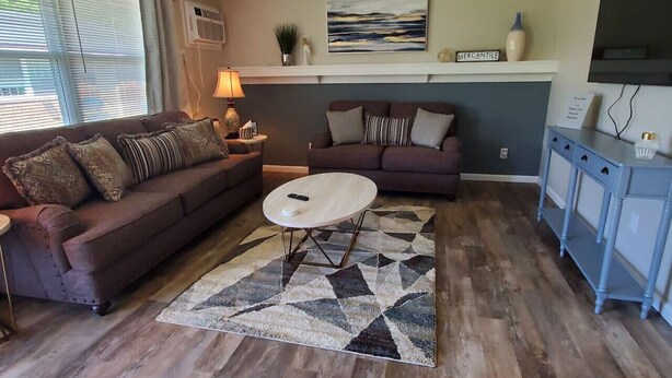 A living room with two sofas, a coffee table, a rug, and a TV on a stand.