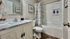 Une salle de bain avec un lavabo, des toilettes et une baignoire en marbre.