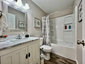 Ein Badezimmer mit Marmorwaschbecken, Toilette und Badewanne.