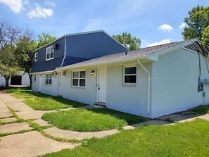 Ein zweistöckiges Haus mit Veranda und Garage.