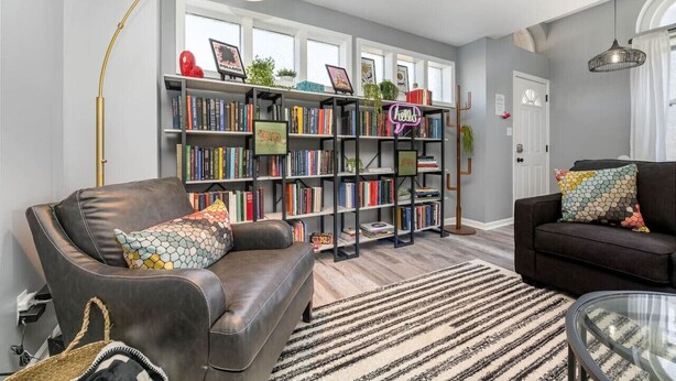 Un salon avec deux canapés, une bibliothèque et une grande fenêtre.