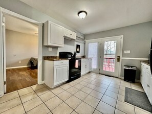 A kitchen with white cabinets, a black oven, and a tiled floor. - 30 Royal #2 · Comfortable Two Bedroom on Royal in Springboro (Springboro)