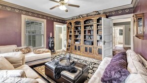 A living room with a sofa, a coffee table, and a bookshelf. - Tower Suite in Historic Mansion B&B, 9 min from Lambeau Field (Green Bay)