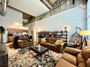 Ein modernes Wohnzimmer mit einer Sofagarnitur, einem Couchtisch und einem Hängekorbstuhl.