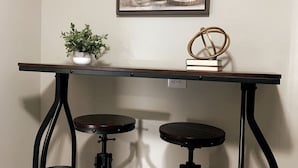 A table with two stools, a potted plant, and a framed picture on the wall. - 3311 Evanston · Large Renovated 4 BDR + Close to DTWN + Laundry (Cincinnati)