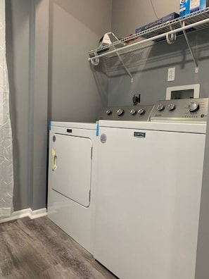 A laundry room with a Maytag washer and dryer, a drying rack, and a small shelf with items. - 5145 Porsche · Newly Remodeled 2 BDRM Ranch- Attached Home (Liberty Township)
