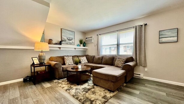 A living room with a sectional sofa, a round coffee table, and a shag rug. - 219 Maxwell St - Unit A · Newly Renovated Franklin Flat (Franklin)