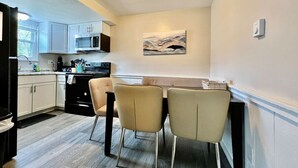 A compact kitchen with a dining area, featuring a microwave, stove, and cabinets. - 219 Maxwell St - Unit A · Newly Renovated Franklin Flat (Franklin)