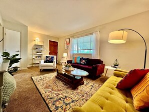 A living room with a sofa, armchair, coffee table, and a lamp. - Nice Place for the Budget Conscious (Middletown)