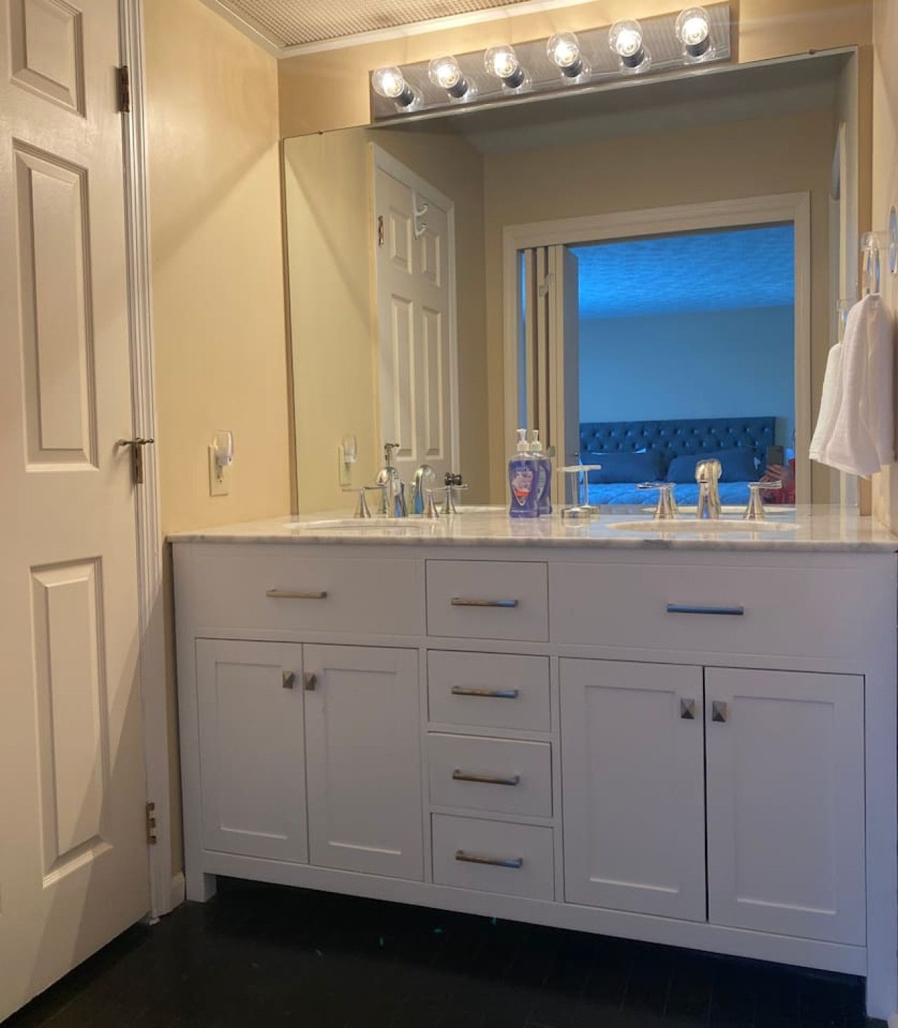 A bathroom with a vanity, a mirror, and a window with a view.