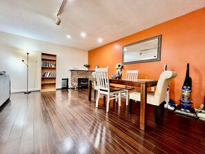A dining area with a wooden table and chairs, a bookshelf, and a fireplace. - 30 Royal #3 · Royal Treatment Studio near highway (Springboro)