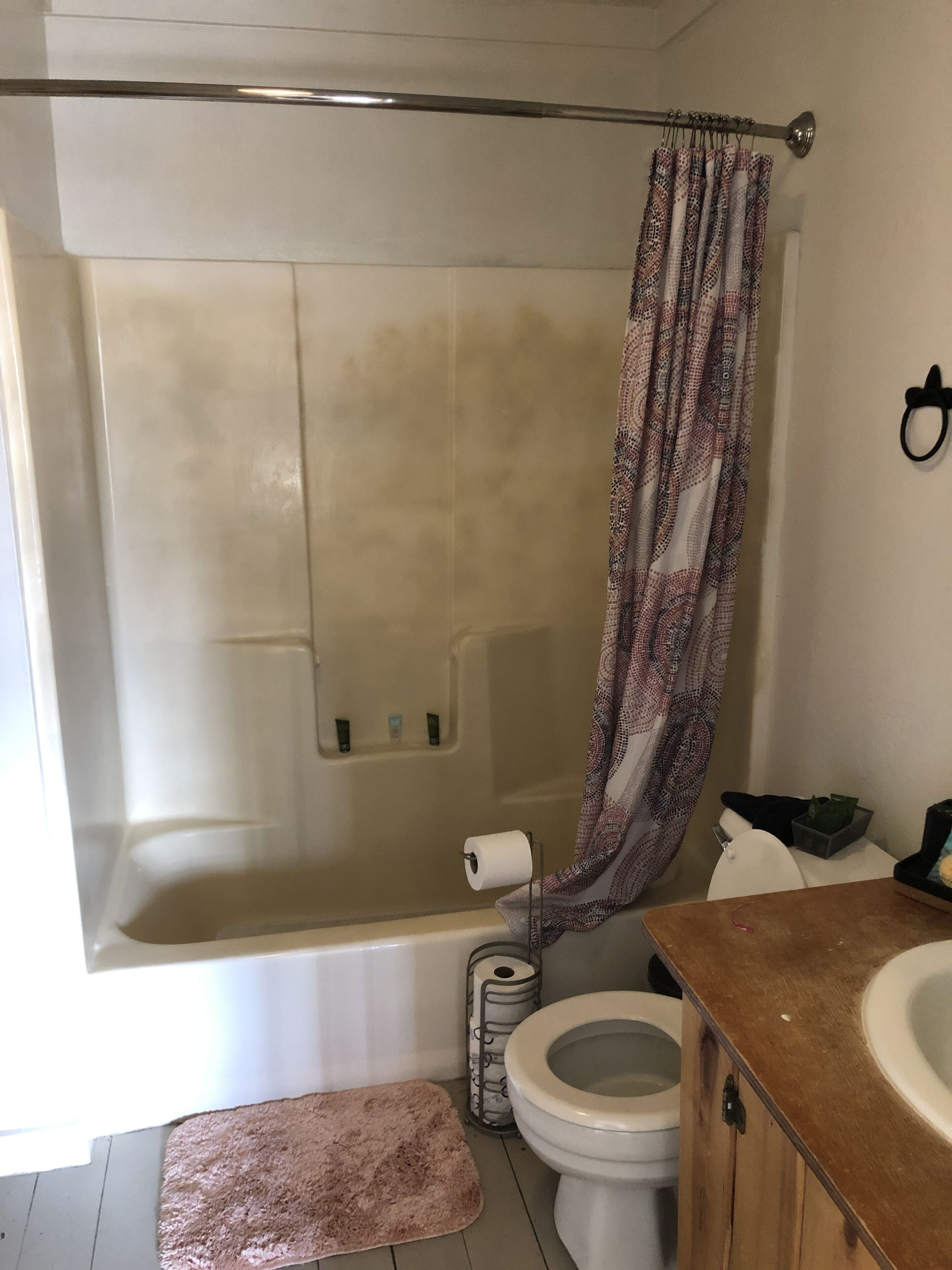 A bathroom with a shower, toilet, and sink.