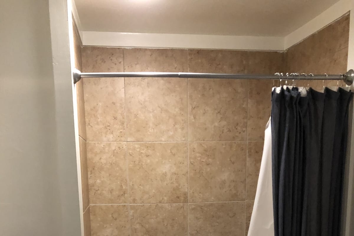 A bathroom with a bathtub, toilet, and a shower curtain.