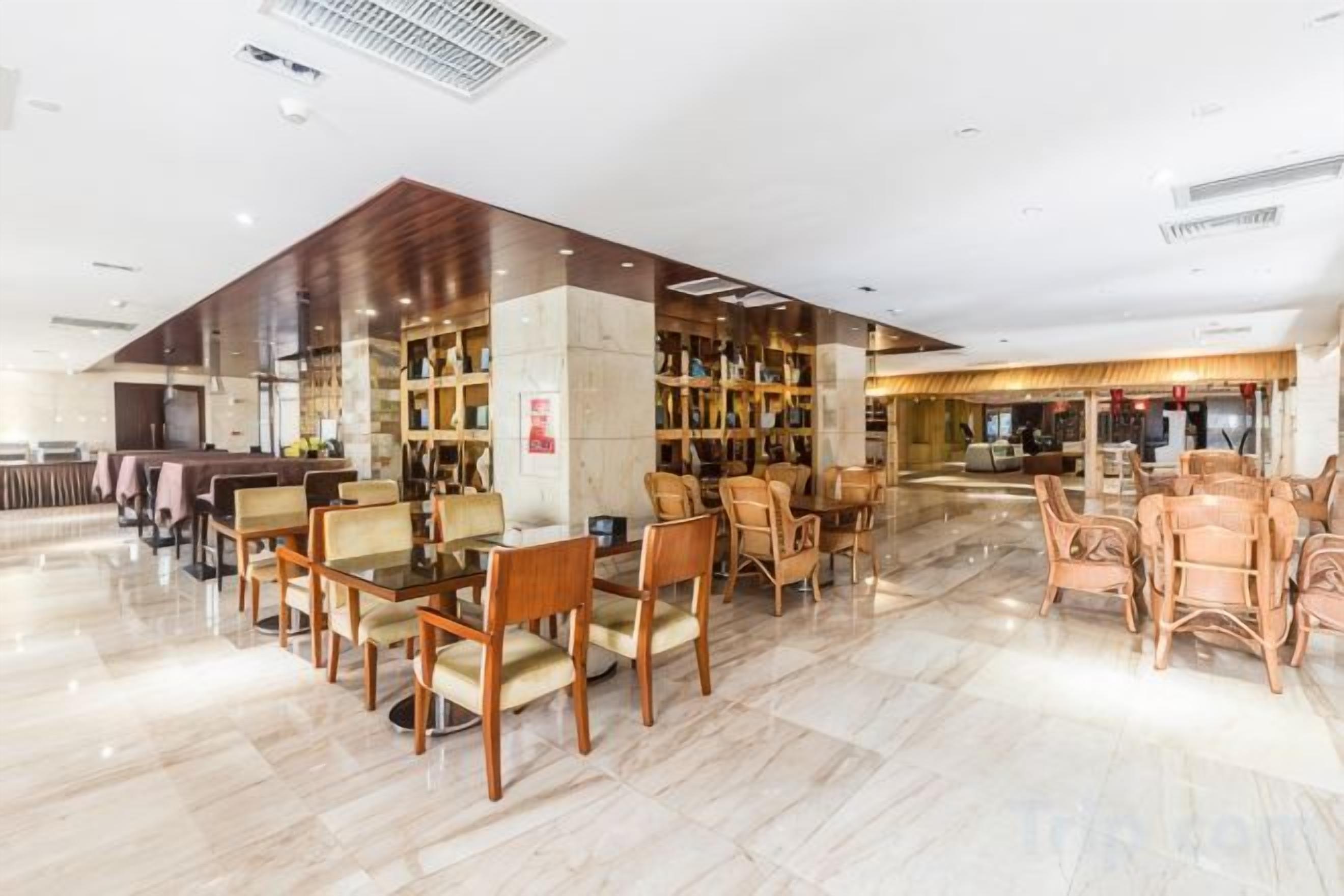 Un vestíbulo amplio con mostrador de recepción, zona de estar con sillas y una gran estantería.