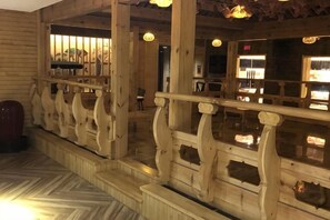 A wooden interior with a railing, a herringbone floor pattern, and a view of the outside. - Xing Yue Business Club (Tongliao)