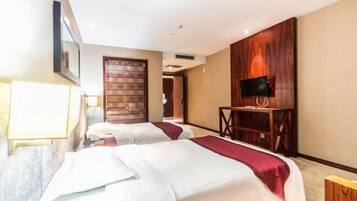A hotel room with two beds, a TV on a wooden stand, and a door with a patterned design.