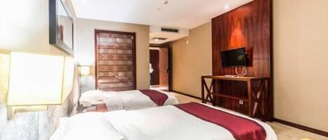 A hotel room with two beds, a TV on a wooden stand, and a door with a patterned design.