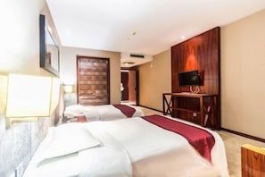 Habitación de hotel con dos camas, un televisor sobre un soporte de madera y una puerta con diseño decorativo.