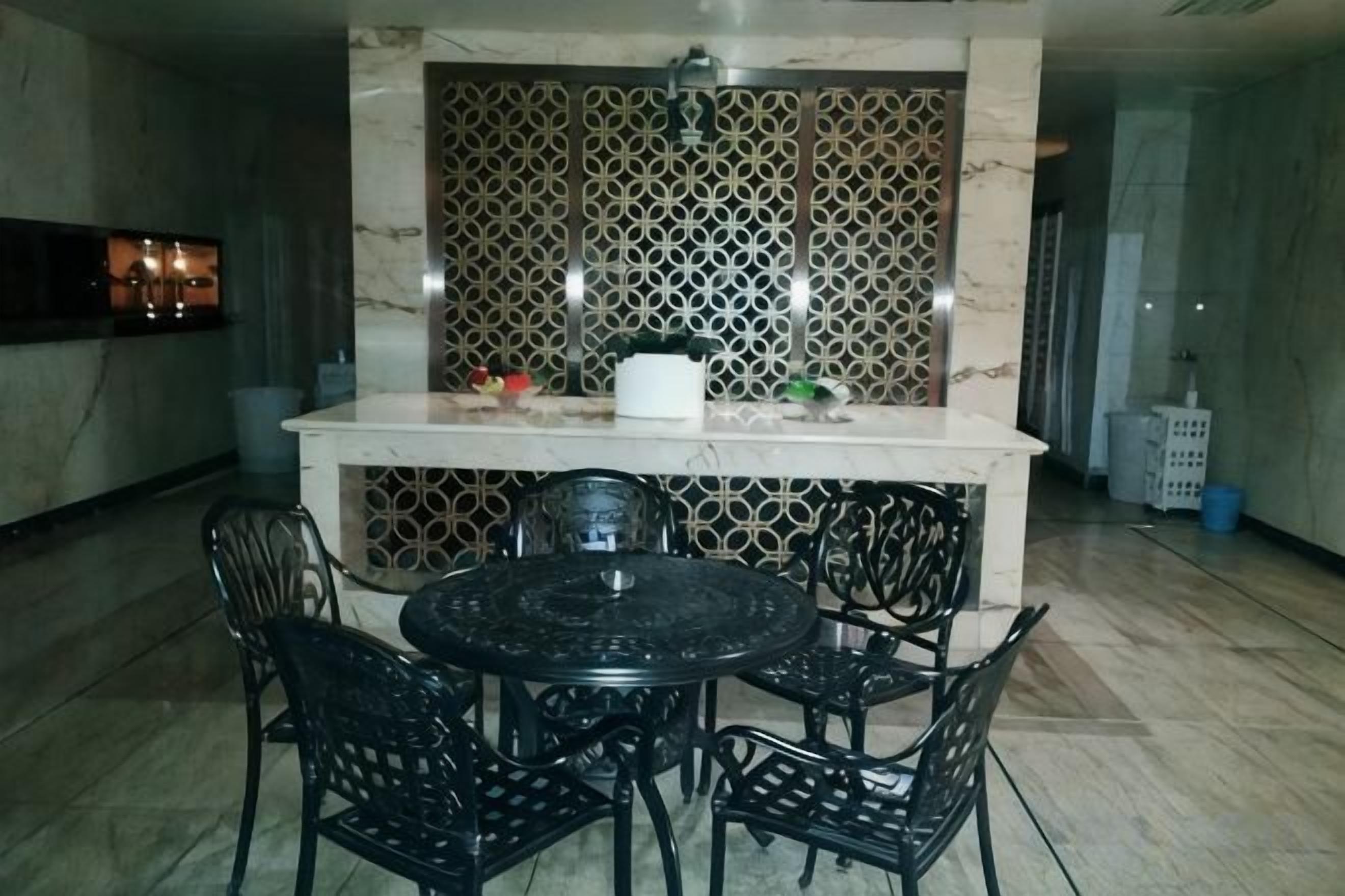 A dining area with a marble countertop, black chairs, and a decorative wall.