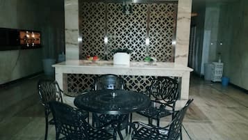 A dining area with a marble countertop, black chairs, and a decorative wall.