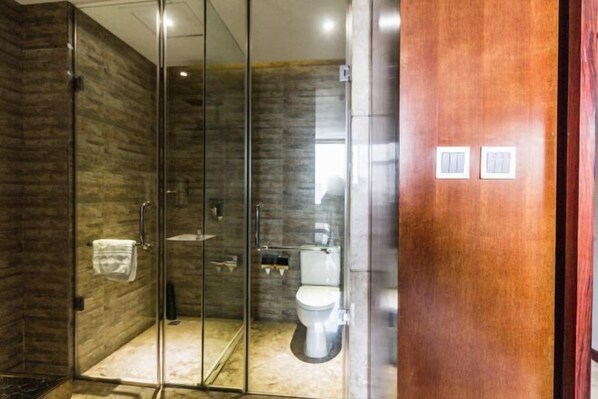 Un baño moderno con ducha acristalada, inodoro y lavamanos.