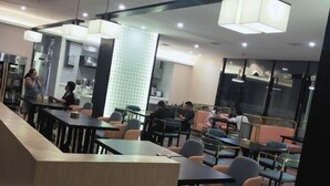 A modern restaurant with tables and chairs, a counter, and a kitchen area in the background. - Laimei Hotel (Jianshi)