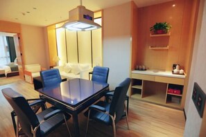 A modern hotel room with a dining table, chairs, a sofa, a desk, and a plant. - Laimei Hotel (Jianshi)