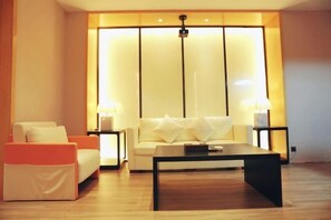 A modern living room with a sofa, a coffee table, and two lamps. - Laimei Hotel (Jianshi)