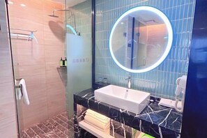 A modern bathroom with a glass-enclosed shower, a marble sink, and a round mirror with a lighted frame. - Laimei Hotel (Jianshi)