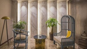 A lobby with two chairs, a round table, and a potted plant. - Laimei Hotel (Jianshi)