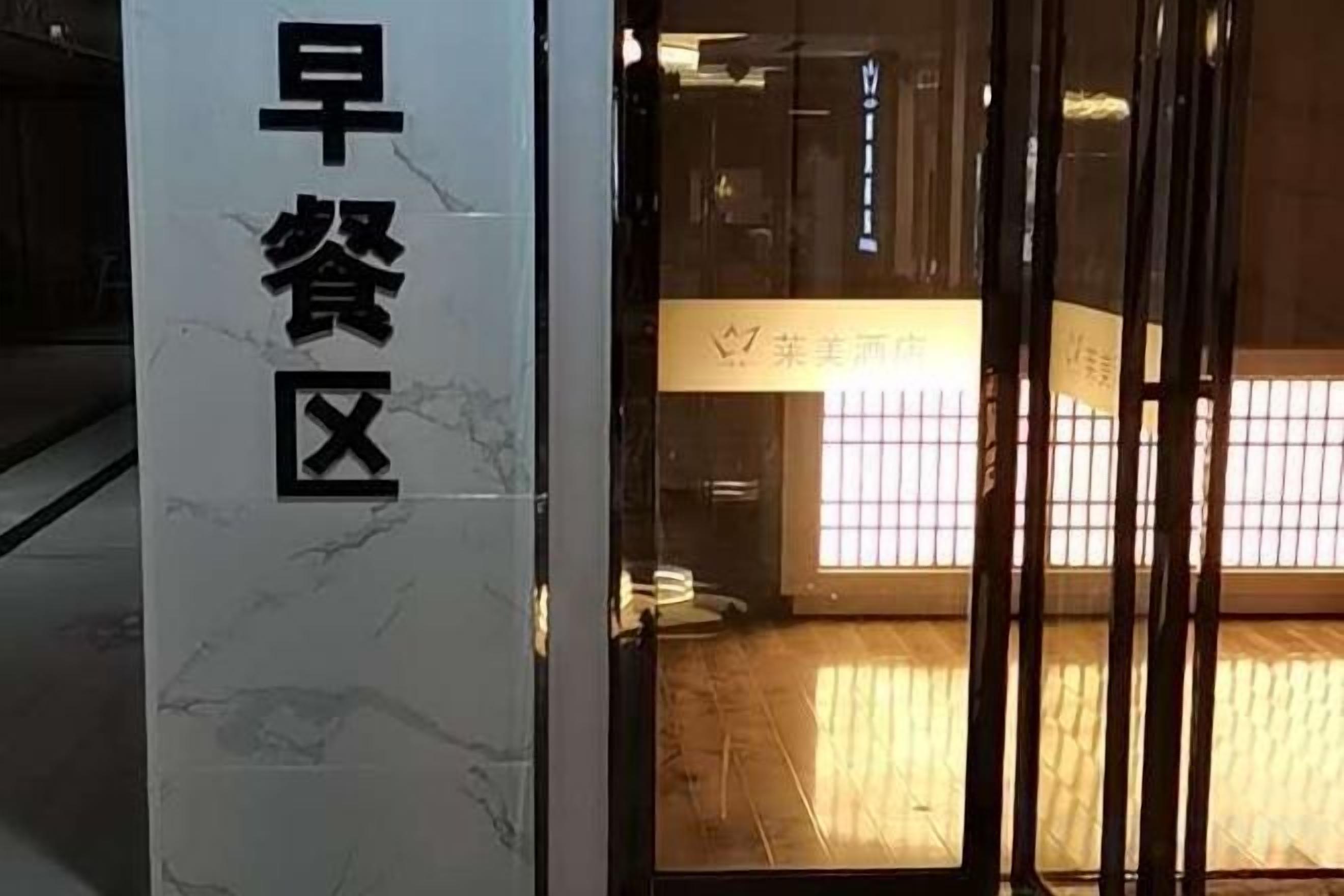 A building entrance with a sign reading 'Early Dining Area' and a reception desk with a sign in a foreign language.
