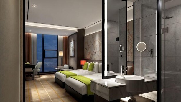 A modern hotel room with a large bed, a separate sitting area, a bathroom with a large mirror, and a view of the city. - Laimei Hotel (Jianshi)