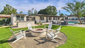 A backyard with a fire pit, outdoor seating, a pool, and a house with a patio. - Walk to Downtown Palm Desert: Home w/ Pool Access (Palm Desert)