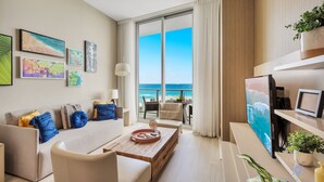 A modern living room with a sofa, coffee table, and artwork on the wall. A large window offers a view of the ocean. - Amazing apartment Lyfe Resort-& Residences- Ocean view! (Hollywood)