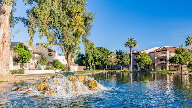 A serene water feature with rocks, surrounded by lush greenery and residential buildings. -  NEW & GORGEOUS Lakefront ZEN 3 bedrooms [2 KING +1 Queen] (Phoenix)